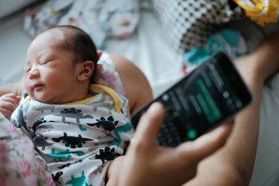 Mother holding baby and phone