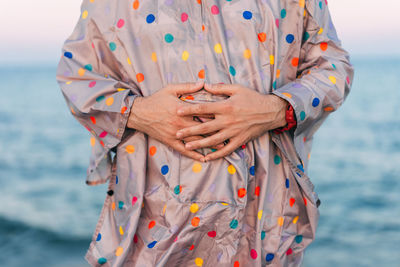 Close-up of woman standing by sea against sky