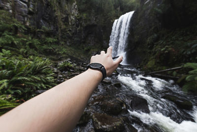 Man reaching for waterfall