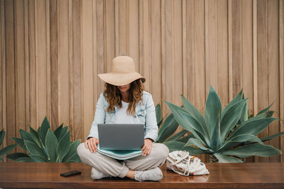 Woman using laptop while sitting on table