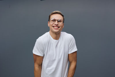 Portrait of young man standing against blue background