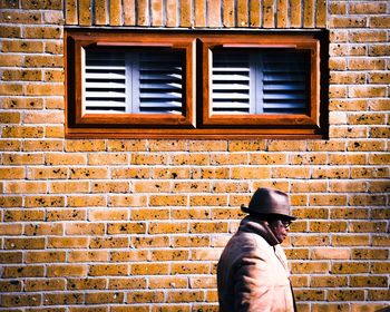 Low section of man standing on brick wall