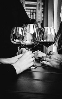 Midsection of people holding glass of table