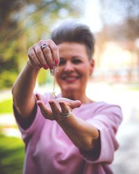 Mature woman holding k letter pendant