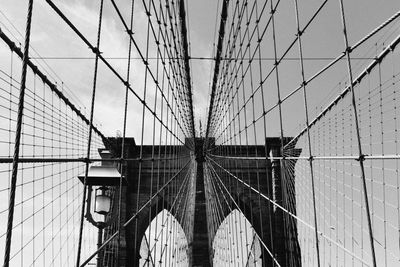 Low angle view of suspension bridge against sky