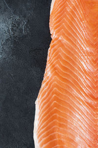 Fresh sea fish, raw salmon fillet on a black stone background. healthy oriental food