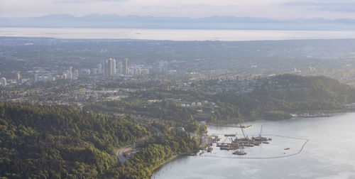 High angle view of city and bay against sky