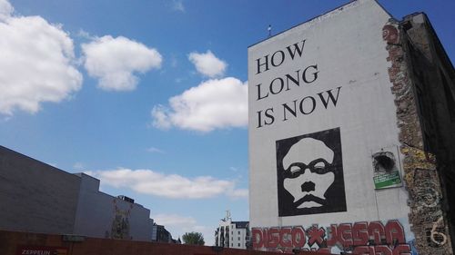 Low angle view of text on building against sky