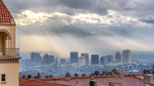 Buildings in city against cloudy sky