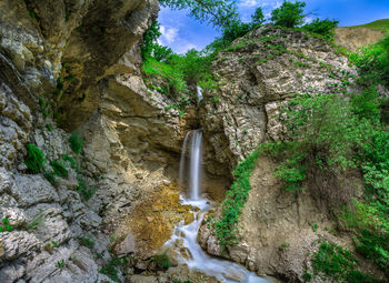 Scenic view of waterfall against rock formation