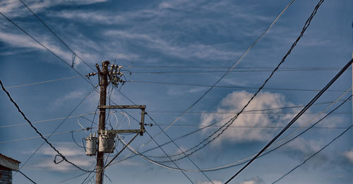 Low angle view of electricity pylon against sky