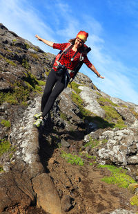 Low angle view of person on cliff against sky