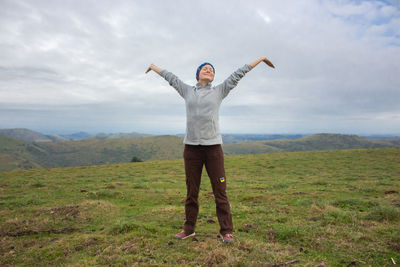 Rear view of woman with arms raised standing on mountain. ukrainian tourist girl.