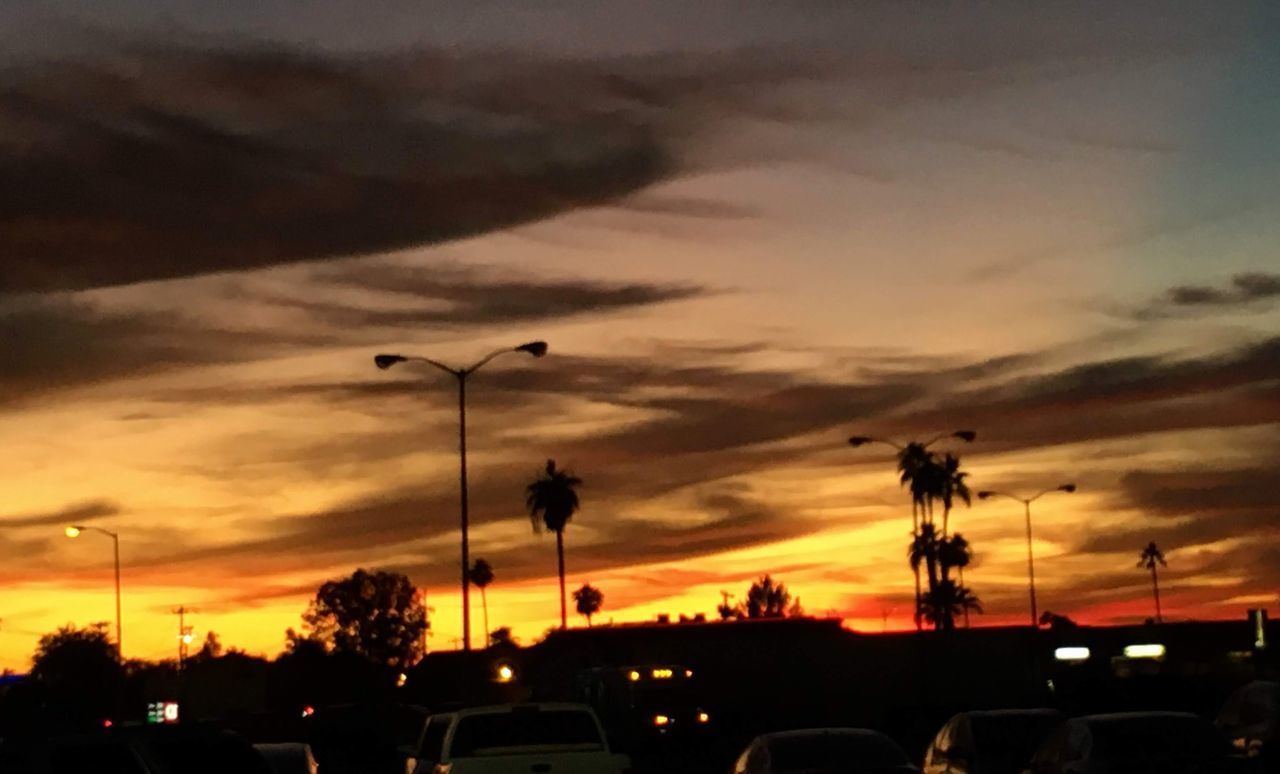 SILHOUETTE CARS ON STREET AGAINST SKY AT SUNSET