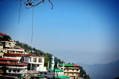 Buildings in city against clear blue sky