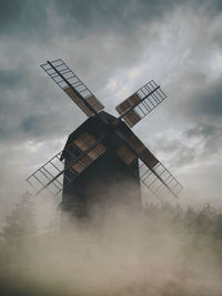 Low angle view of traditional windmill against sky