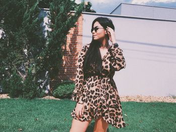 Full length of young woman standing against plants