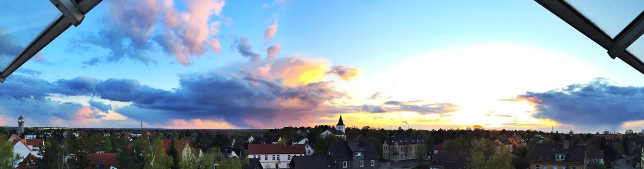 building exterior, architecture, built structure, sky, cloud - sky, sunset, city, residential district, cityscape, residential building, residential structure, cloud, house, cloudy, town, high angle view, tree, crowded, orange color, sunlight