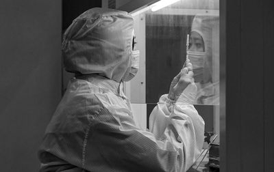 Side view of man and woman looking through glass window