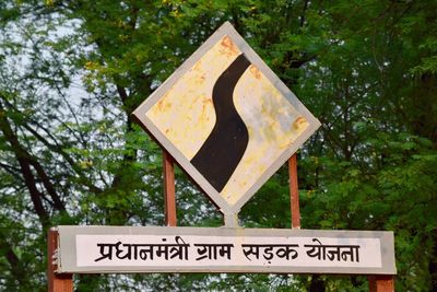 Close-up of road sign against trees