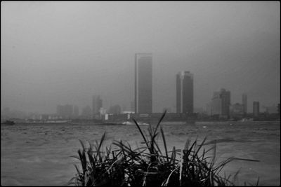 Scenic view of bay against sky in city