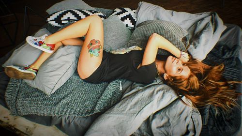 High angle view of woman resting on bed at home