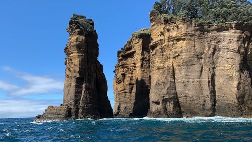 Rock formations in sea against sky