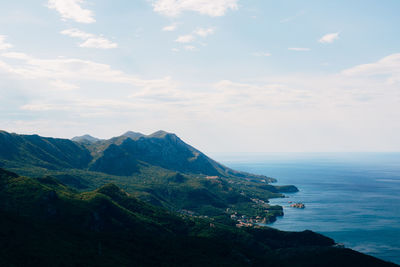 Scenic view of sea and mountains against sky