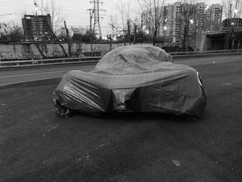 Man sleeping on road by street in city