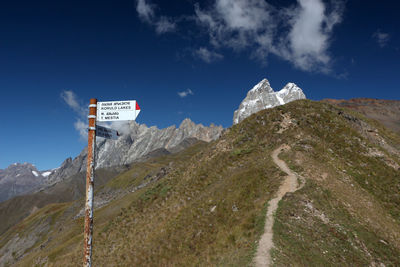 Information sign on mountain against sky