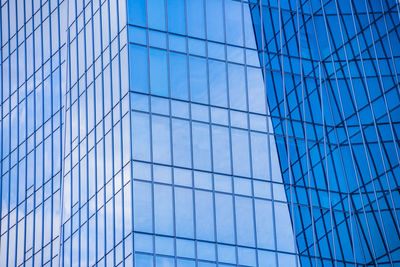 Low angle view of glass building against sky