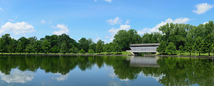 Scenic view of lake by trees against sky