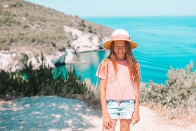 Portrait of young woman standing at beach