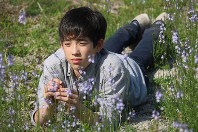 Full length of boy holding flowers on field