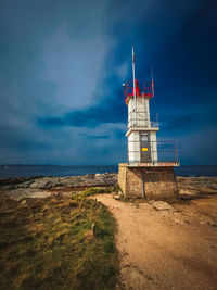 Lighthouse by sea against sky