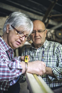 Workers measuring wood in workshop