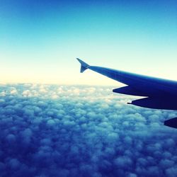 Cropped image of airplane flying over cloudscape