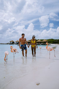 People enjoying on beach against sky