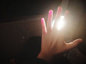 Close-up of hand on illuminated light