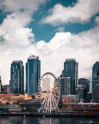 Modern buildings in city against cloudy sky