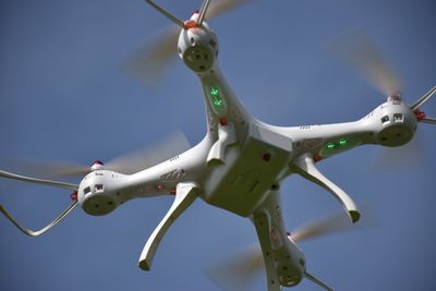 Low angle view of drone flying against clear sky