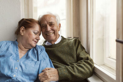 Portrait of happy senior couple at the window