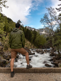 Rear view of man on mountain against sky