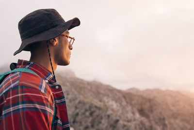 Side view of man wearing hat and admiring sunset on vacation