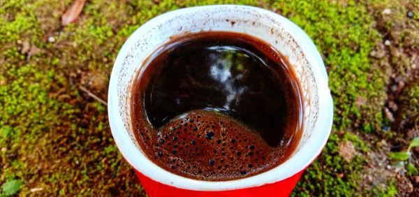 Directly above shot of coffee cup on field