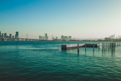 Scenic view of sea and buildings against clear sky