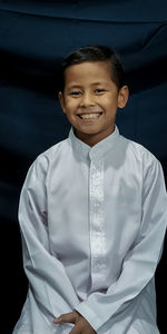 Portrait of young man standing against wall