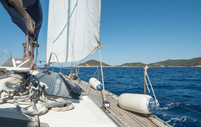 Sailboats sailing on sea against clear blue sky