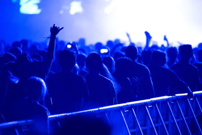 Crowd of people enjoying a live concert in blue stage lights