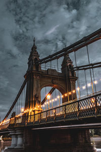 Bridge over river against cloudy sky